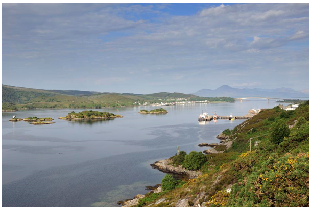 Skye Bridge in the distance with scattered settlements and harbours on both sides of the loch.