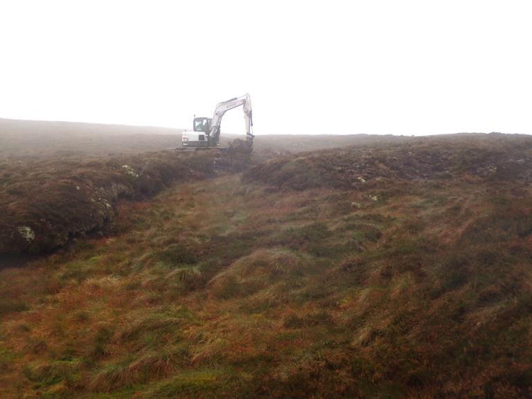 An excavator working on an area of peatland.
