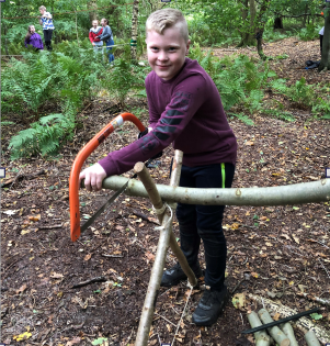 St Paul's Primary pupil sawing a log