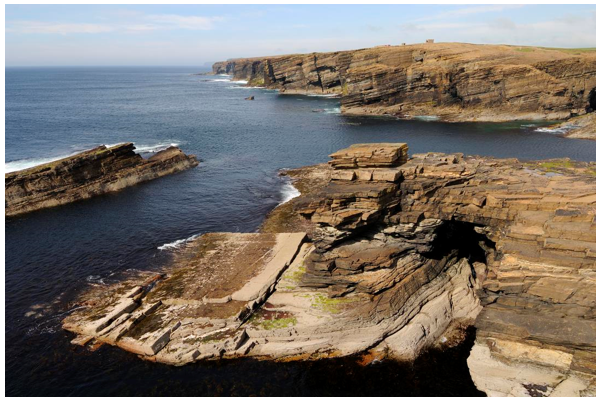 Stratified cliffs with wave cut platform and sea caves