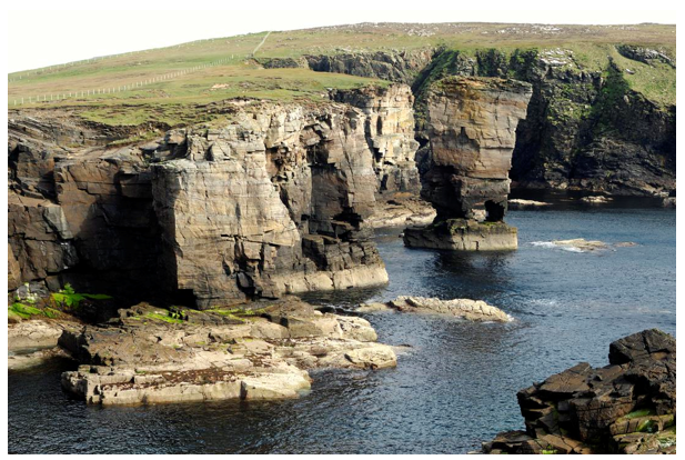 Steep cliffs , a stack with an arch and a wave cut platform at Yesnaby