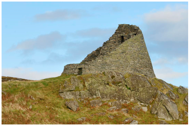 Partially ruined round broch situated on a rocky outcrop,