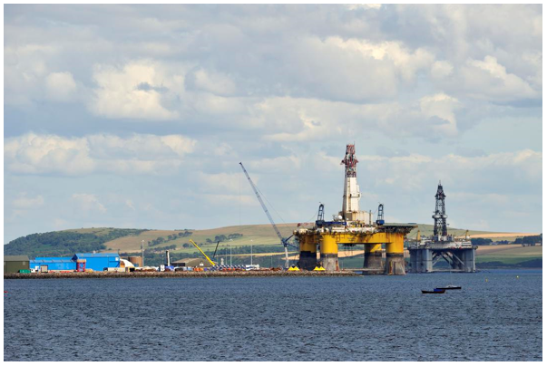 Nigg port with a yellow rig structure docked.
