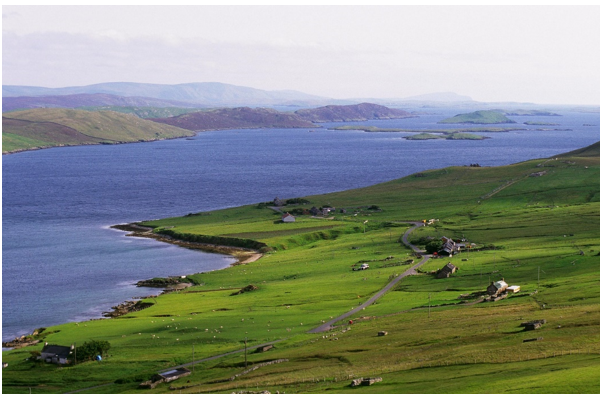 farm land slopes towards the voe, a flooded valley with islands,