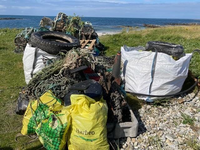 Bags of rubbish on beach after beach clean involving 122 people