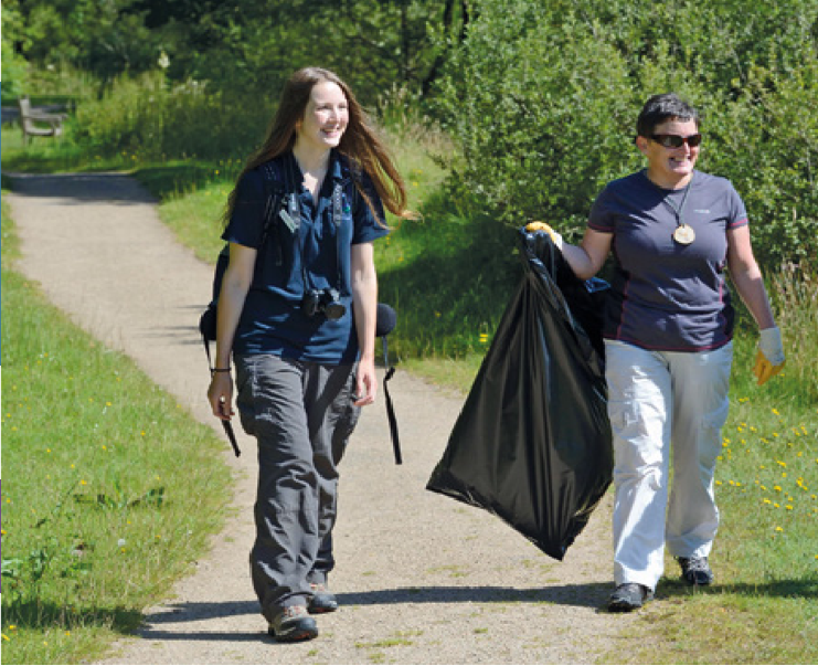 two people picking up litter in nature