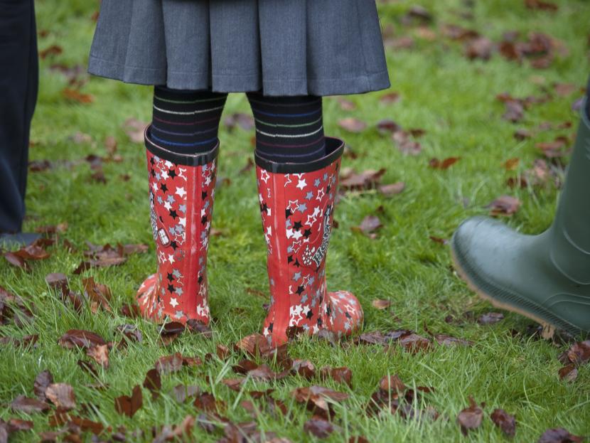child with wellies on learning outdoors