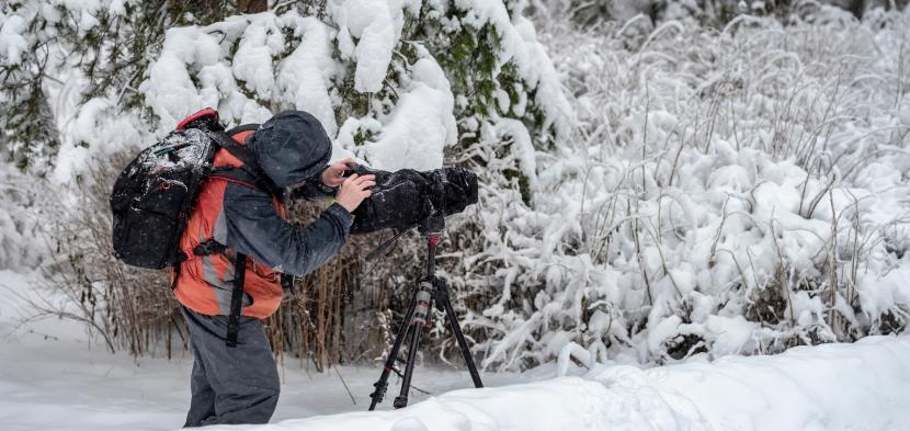 Person looking through a camera in a snowy setting
