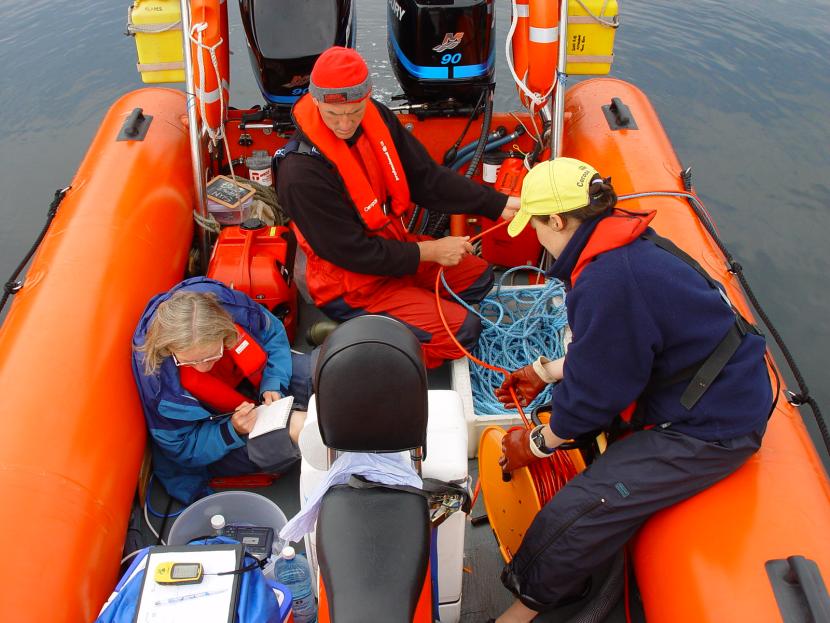 Three researchers in a rigid inflatable boat. 