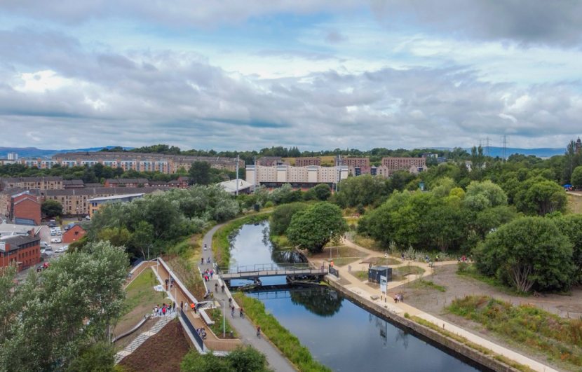 Birds eye view of the canal and the garscube bridge, with various users from cyclist, walking and children playing. The claypits located to the right side of the image. 