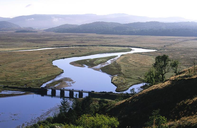 Moine Mhor NNR, with a river and bridge in the foreground and hills in the background.