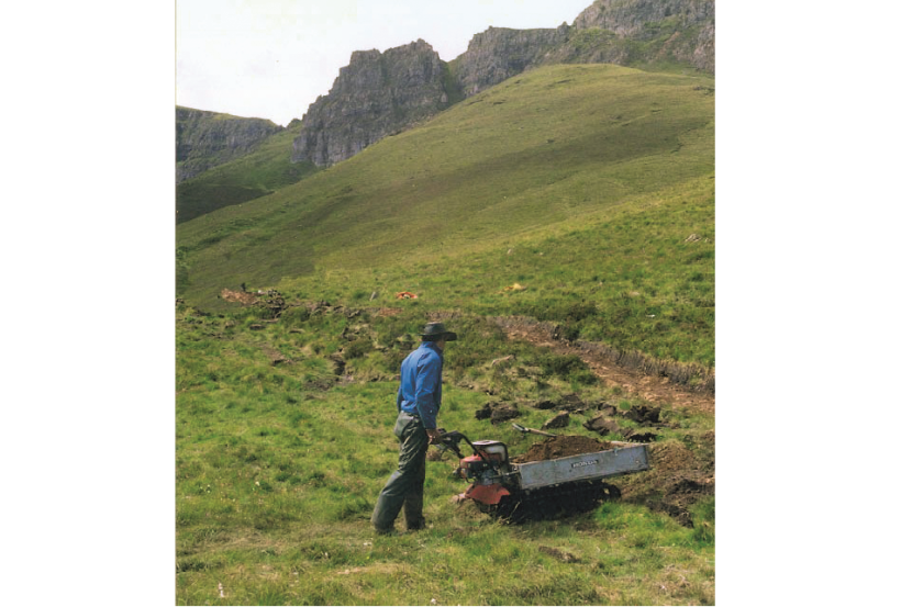 Photo of a power barrow being used to transport path materials.