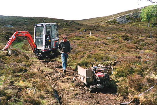 Mini digger and power barrow on a path repair project