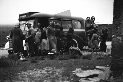 Case study - Shetland peat bus with a group of people standing around the bus