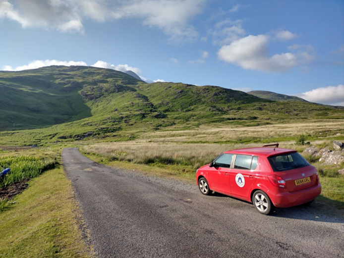 The Mull and Iona Ranger Service car parked at the side of the road with the hills and grassland arround it.