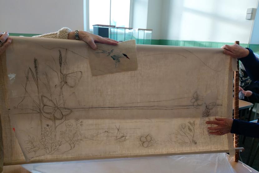 A piece of fabric with embroidered images of butterflies and flowers.