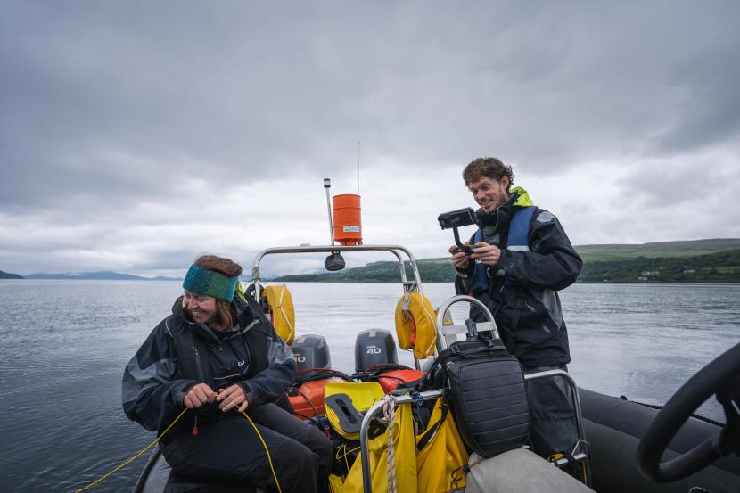 two people on a boat carrying out survey work