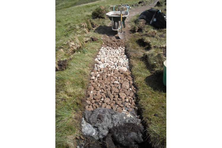 Graded aggregate on top of the sheep fleece compacting it so the top of the path is still level with the surrounding ground