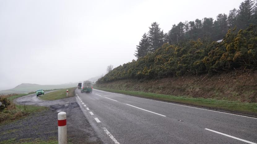 A layby alongside the A9 on the left, with extensively cut back gorse scrub along the verge on the opposite side. 