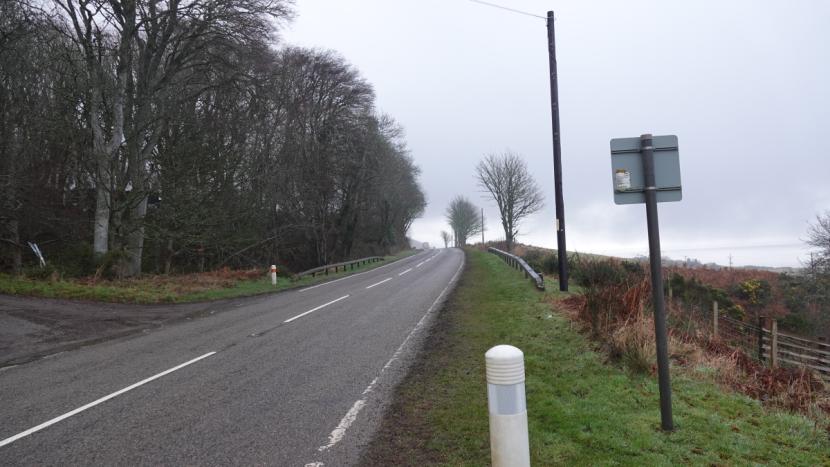 The A9 viewed facing north, woodland to the left of the road and more open land on the right. 