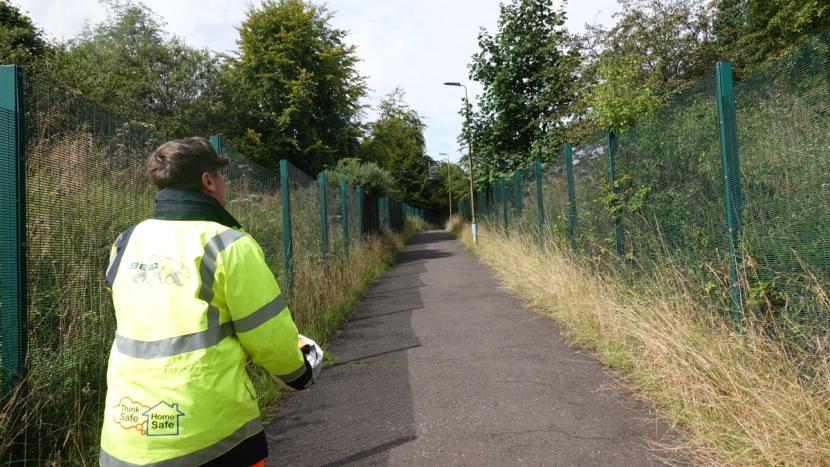 A tarmac footpath with two-metre high green security fencing on both sides between land parcel 2 and 3. 