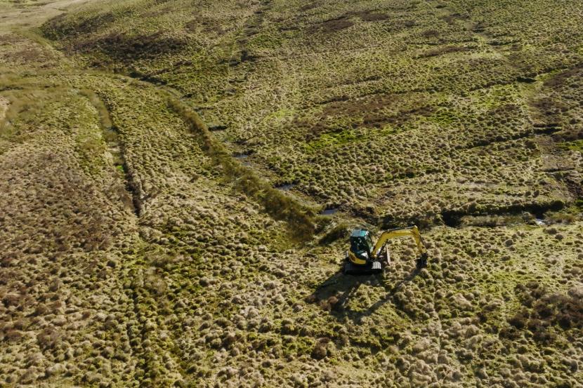 A digger working on a hillside.