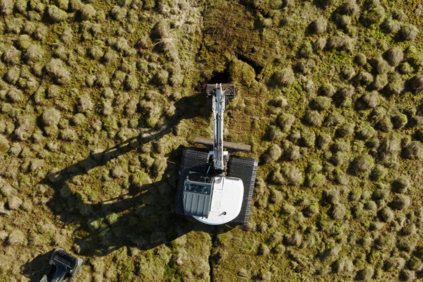 Overhead view of a digger carrying out peatland restoration work 