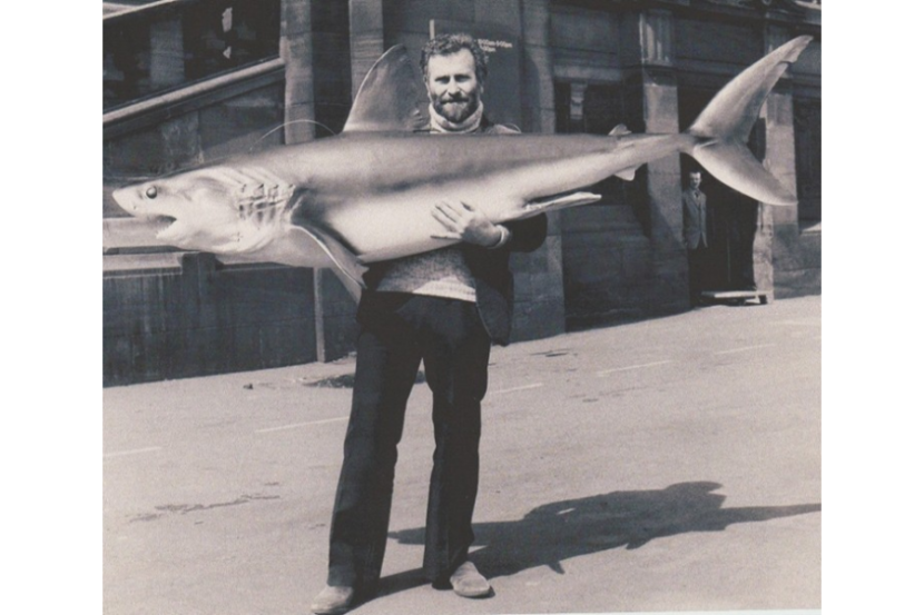 A man holding a model of a porbeagle