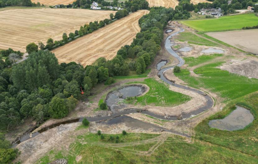 River winding through an area of field and woodland