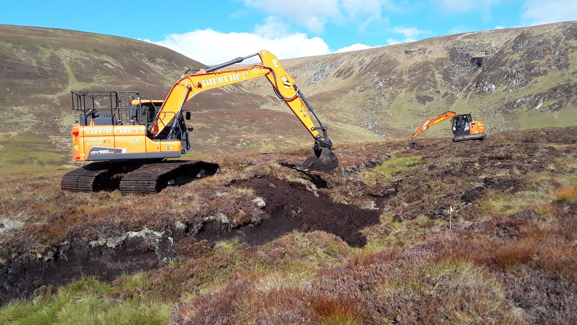 Excavator re-profiling a peatland gully