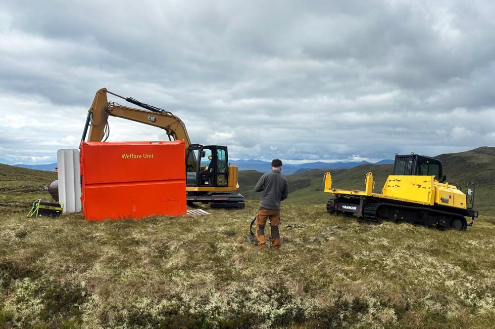 Restoration machinery and worker on peatland with hills in the background