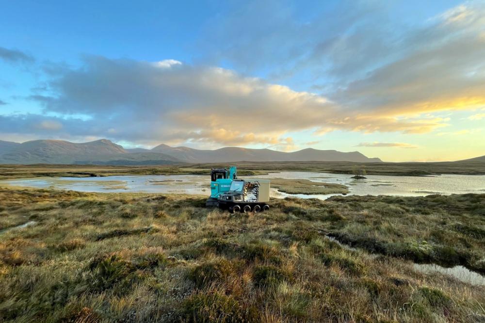 Restoration machinery on peatland with river and hills in the background