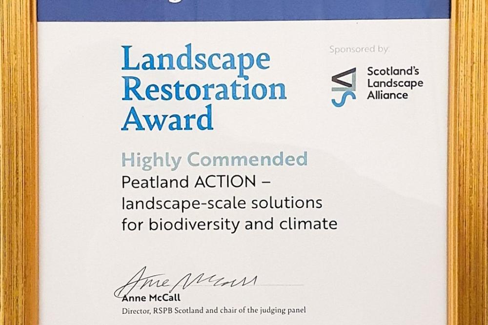 A framed certificate displaying Peatland ACTION as Highly Commended in the Nature of Scotland (2023) Landscape Restoration Award category.