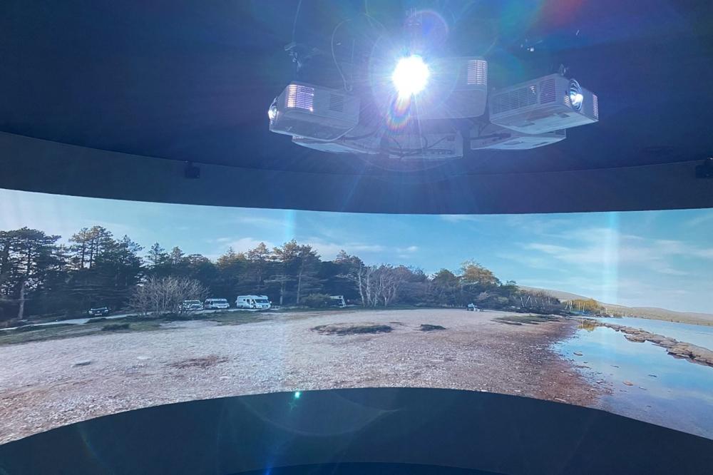 Interior of the Spirit of the Highlands &amp; Islands immersive 360 degree portal, with two visitors admiring the film of the ferry sailing to the Isle of Arran
