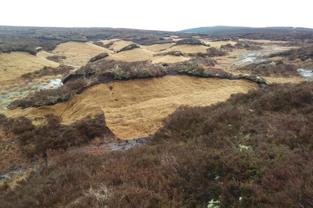 Areas of hummocky bare peat after coir matting added. The coir matting helps to stabalise the bare peat forming a barrier against the elements and a foothold for the colonisation of peatland plants.